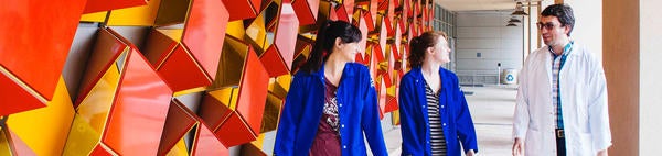 students walking in Genomics building entryway, red art installation on wall  (c) UCR / CNAS