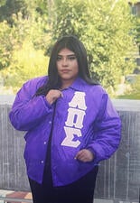 Leslie standing with letterman jacket