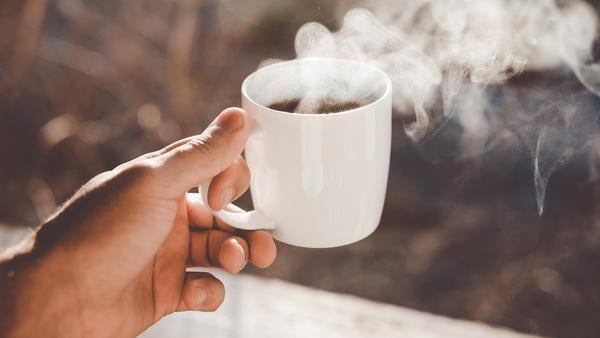 hand holding mug of coffee